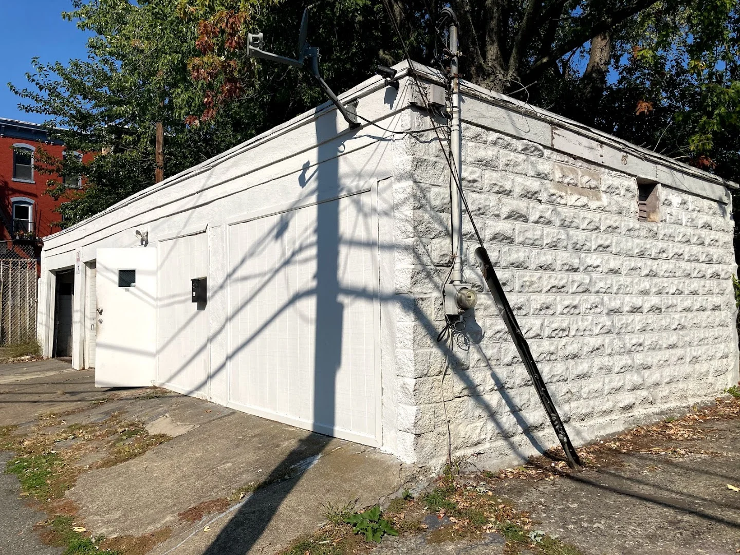 Street-level exterior photograph of the existing white masonry garage